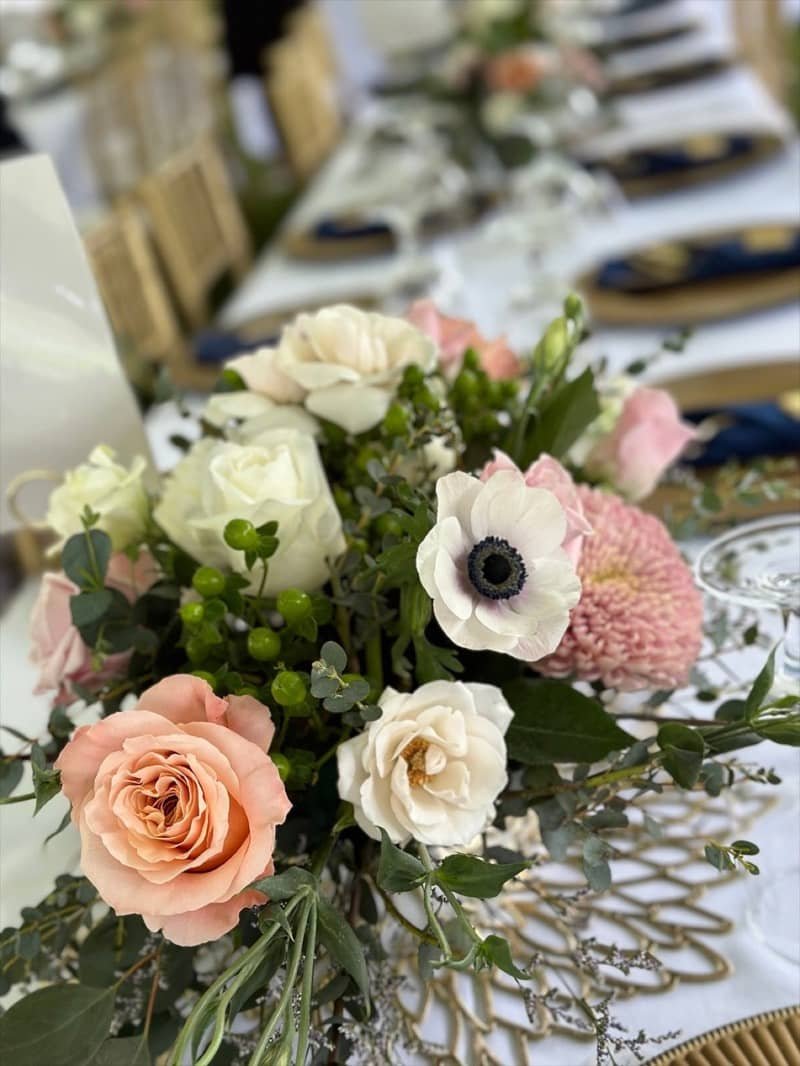 Table centerpiece with roses, anemones, and eucalyptus